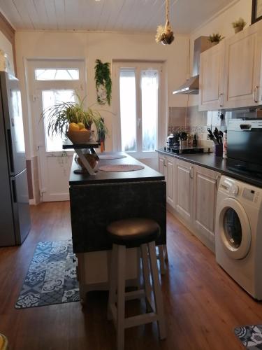 une cuisine avec un îlot et un comptoir dans l'établissement Maison cocoon et chaleureuse, à Marcilly-sur-Seine