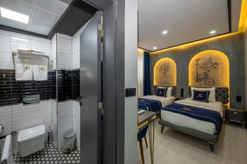 two beds in a small room with a bathroom at Hotel California in Istanbul