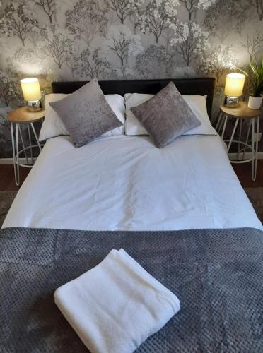 a bed with white sheets and pillows and two lamps at Hardwick Haven, Sedgefield - Near Hardwick Hall in Stockton-on-Tees