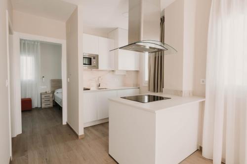 una cocina con armarios blancos y fregadero. en Apartamentos SubUp, en Cabo de Palos