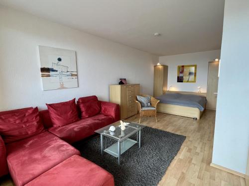 a living room with a red couch and a bed at Berolina 519 - Ostsee Weitblick in Dahme