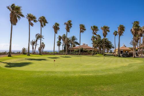 a view of a golf course with palm trees at Barceló Tenerife Royal Level in San Miguel de Abona