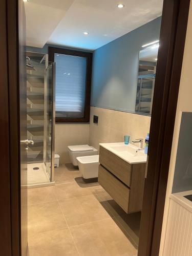a bathroom with a toilet and a sink and a shower at Villa Russo Apartment in Trecastagni