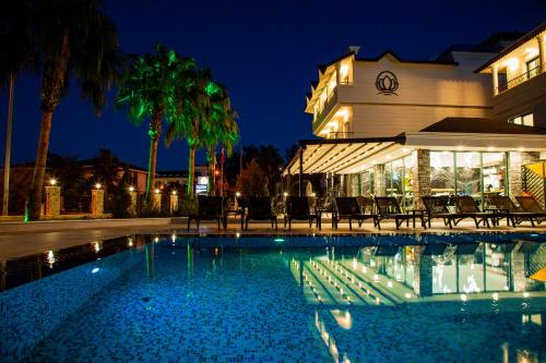 a swimming pool in front of a building at night at Edem Flower Hotel in Kemer