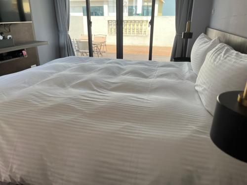 a large white bed in a bedroom with a window at 飛鳥集行館 in Hu-hsia