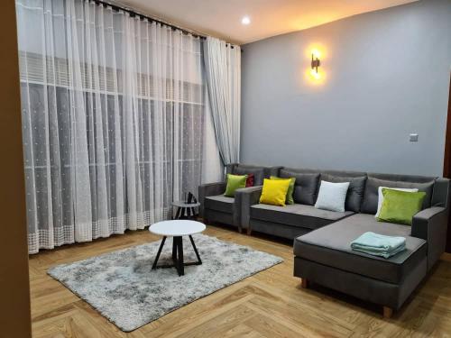 a living room with a couch and a table at Unia fancy flats 3 bed room apartment- Flat 2 in Kampala