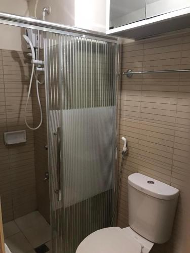 a bathroom with a shower and a toilet and a shower at Moldex Residence in Baguio