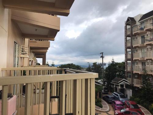 uma varanda de um edifício com carros estacionados num parque de estacionamento em Moldex Residence em Baguio