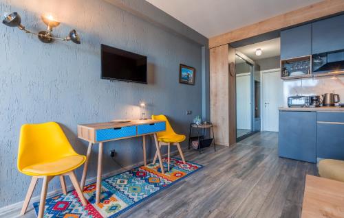 sala de estar con mesa y 2 sillas amarillas en Touch the Mountains, Twins Hotel, New Gudauri, en Gudauri