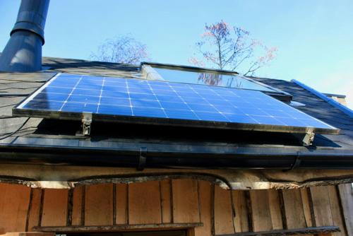 un panneau solaire sur le toit d'une maison dans l'établissement Tretopphytter På Grensen - Beverhytta med robåt og gjeddefiske, à Halden