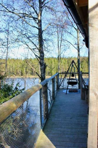 a wooden bridge over a river with a swing at Tretopphytter På Grensen - Beverhytta med robåt og gjeddefiske in Halden
