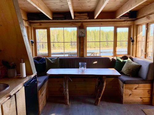 a living room with a couch and a table at Tretopphytter På Grensen - Beverhytta med robåt og gjeddefiske in Halden