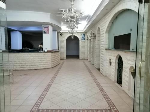 a hallway in a building with a chandelier at Nojoom Hotel in Amman