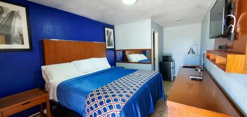 a blue bedroom with a bed and a blue wall at Golden Inn in Seagoville