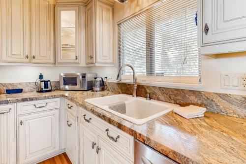 a white kitchen with a sink and a window at Deer Path Cabin in Idyllwild