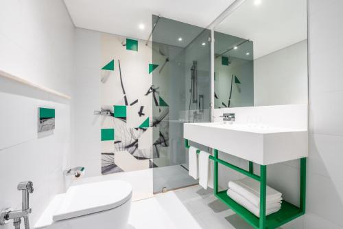 W łazience znajduje się umywalka, toaleta i lustro. w obiekcie Studio M Arabian Plaza Hotel & Hotel Apartments w Dubaju