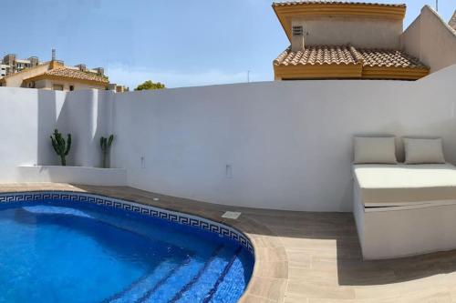 洪達海灘的住宿－Dúplex mediterráneo con piscina y cenador，一个带游泳池的阳台和一张位于大楼内的床铺