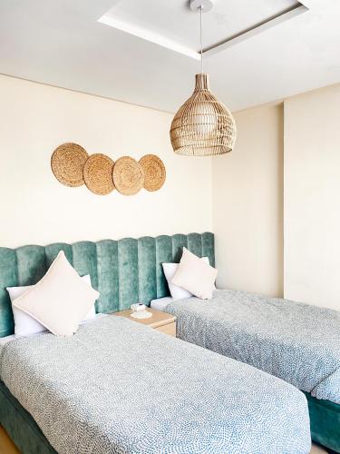 two beds sitting next to each other in a room at Appartement Cosy, vue sur mer in Mohammedia