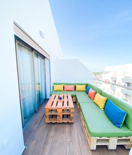 a green couch and a coffee table on a balcony at Appartement Cosy, vue sur mer in Mohammedia