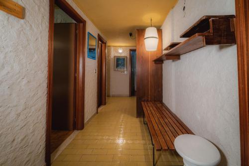 a hallway with a toilet and a wooden bench at Fevri apartment in Madonna di Campiglio