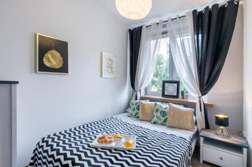 a bedroom with a bed with a tray of food on it at ClickTheFlat Avenue Place Apart Rooms in Warsaw