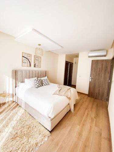 a bedroom with a white bed and a rug at Appartement Cosy, vue sur mer in Mohammedia