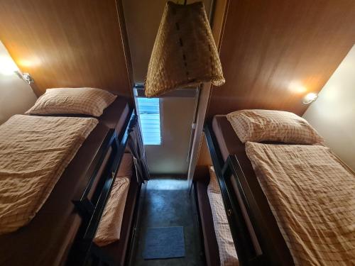 a small room with two beds and a lamp at Non House Bangkok in Bangkok