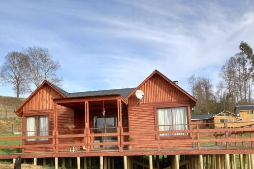 a log cabin with a fence in front of it at Eco Brújula in Villarrica