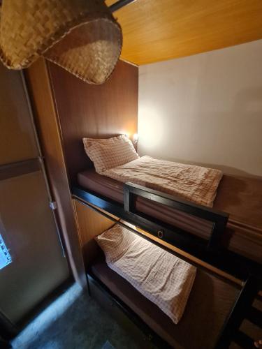 a small room with two beds and towels at Non House Bangkok in Bangkok