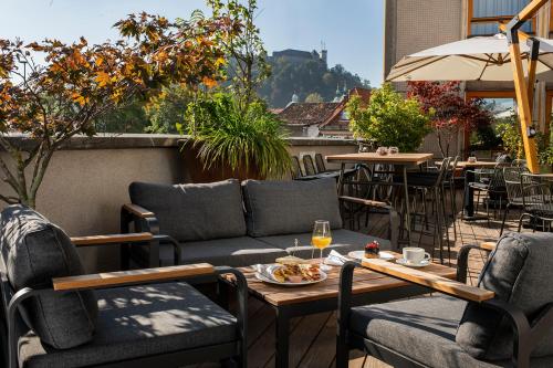 a patio with a couch and a table and chairs at City Hotel Ljubljana in Ljubljana