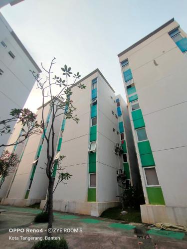 a white building with green and white windows at Zye Room's Apartemen Aeropolis in Tangerang