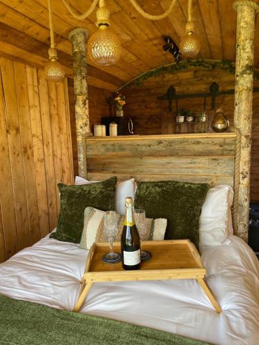 a bed with a bottle of wine on a table at Little Oakhurst in Clitheroe