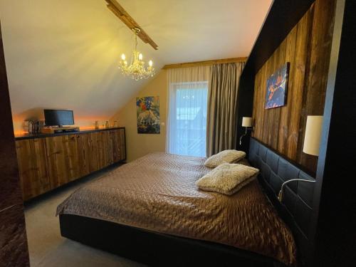 Un dormitorio con una cama grande y una lámpara de araña. en Alpin Haus Turrach en Turracher Hohe