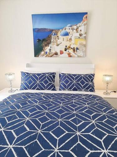 a bedroom with a blue and white bed and a painting at Garden View of Macquarie Park Paradise in Sydney