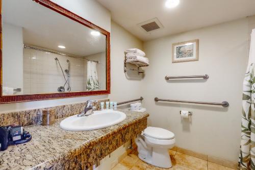 a bathroom with a sink and a toilet and a mirror at Islander on the Beach 111 in Kapaa