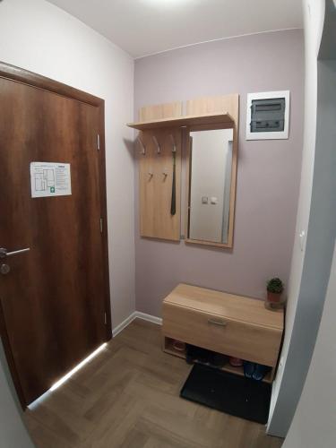a bathroom with a wooden door and a mirror at Apartments Manna Palic in Palić