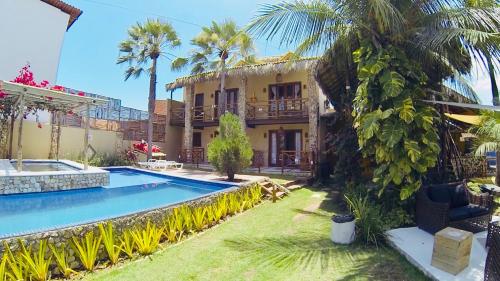 Villa con piscina frente a una casa en Pousada Rosa dos Ventos Lagoinha, en Lagoinha