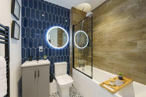 y baño con aseo, lavabo y espejo. en Lilyturf - 2 Bedroom Luxury Apartment by Mint Stays, en Bristol