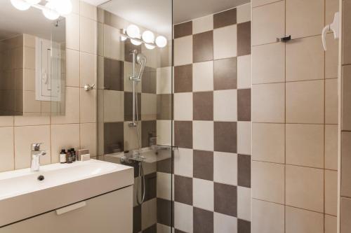uma casa de banho com um lavatório e um chuveiro em Glorious 1BR Apartment in Athens by UPSTREET em Atenas