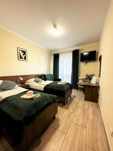 una camera d'albergo con due letti e una televisione di Rezydencja Korab a Międzyzdroje