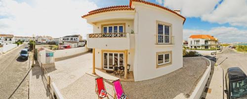 une maison dans une rue avec des drapeaux devant elle dans l'établissement Cosmos Retreat Baleal, à Baleal