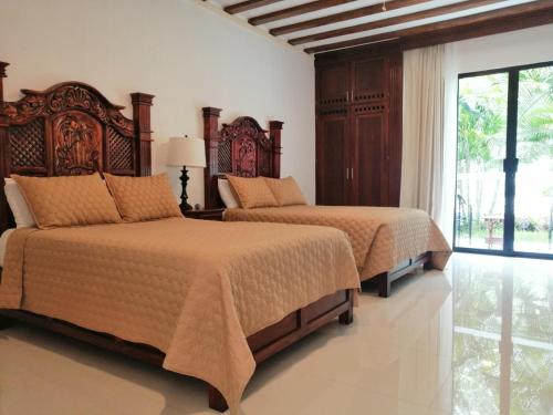 a bedroom with two beds and a window at Casa San Roque Valladolid in Valladolid