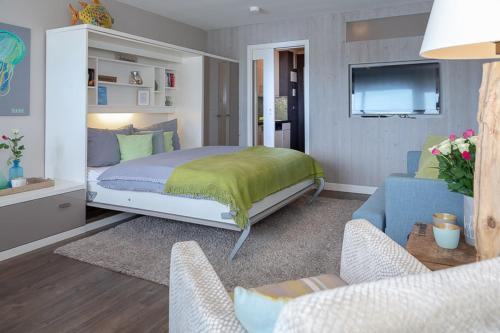 ヴェスターラントにあるAd2 77 Seaside 77のベッドルーム(ベッド1台、ソファ、テレビ付)