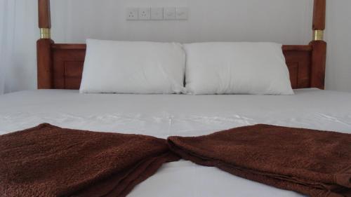 a bed with two brown towels on it at Mirissa Cocoon in Mirissa