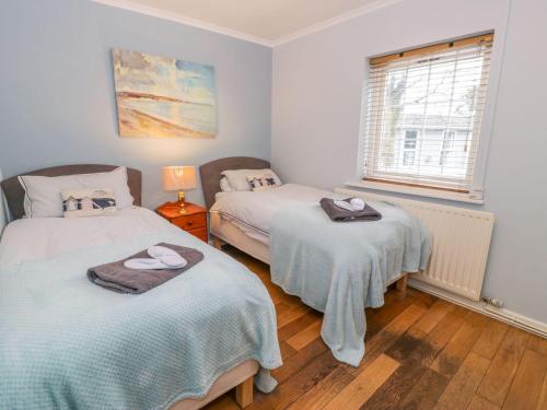 sypialnia z 2 łóżkami i oknem w obiekcie The Orchard w mieście Pwllheli