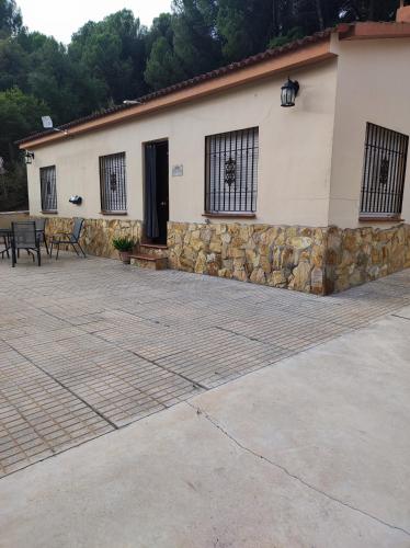 a house with a stone wall and a patio at EL RINCON DE ANGELA in Córdoba