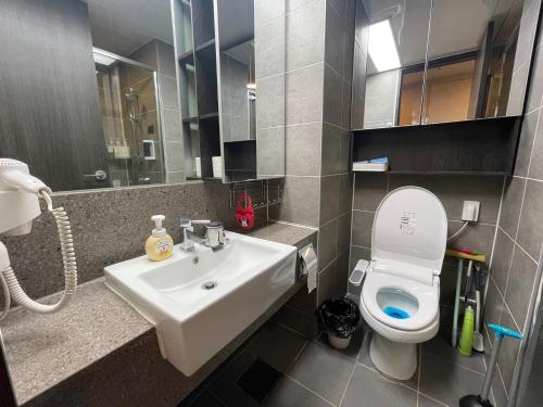 a bathroom with a sink and a toilet and a mirror at Hotel With in Busan