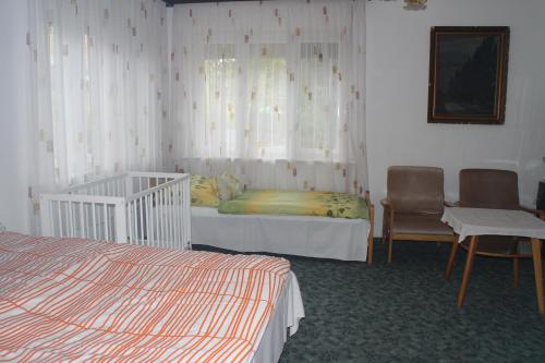シオーフォクにあるEvelin Nyaralóházのベッドルーム1室(ベッド1台付)、窓(ベビーベッド付)