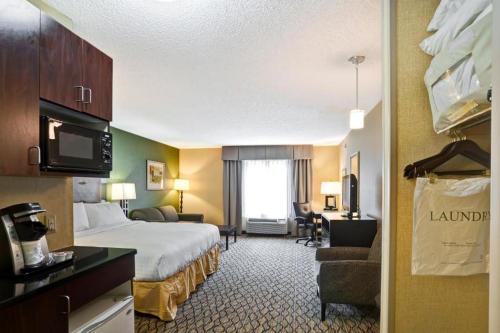 una habitación de hotel con una cama grande y una habitación con en Holiday Inn Express Hotel & Suites Christiansburg, an IHG Hotel, en Christiansburg