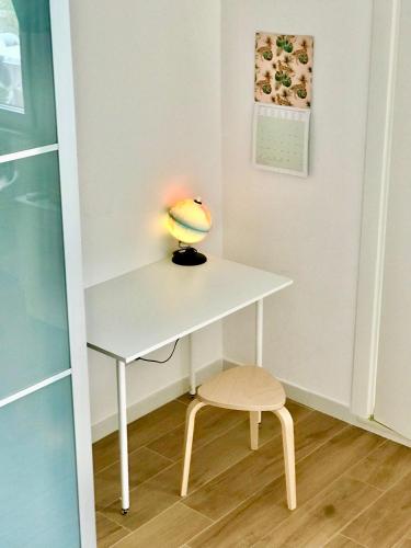 a desk with a lamp and a stool in a room at Stanza e bagno privato, idromassaggio con extra fee, in appartamento in Ferrara